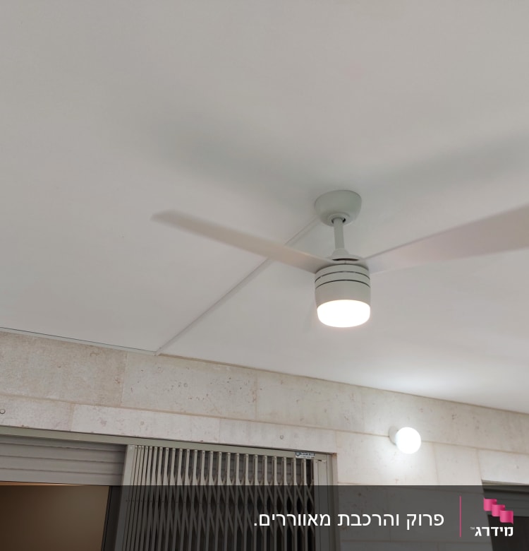 מאוורר תקרה עם תאורה דולקת על תקרה לבנה